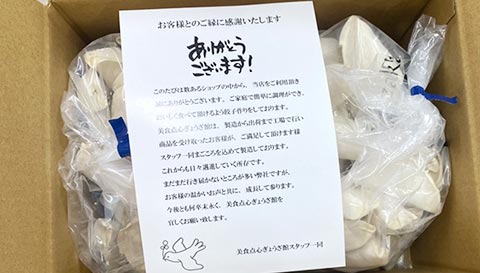 段ボールに丁寧に梱包された餃子とお礼の手紙